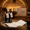 Livret de cave et fiche de dégustation d'un domaine viticole du Chablais posés devant des bouteilles au comptoir